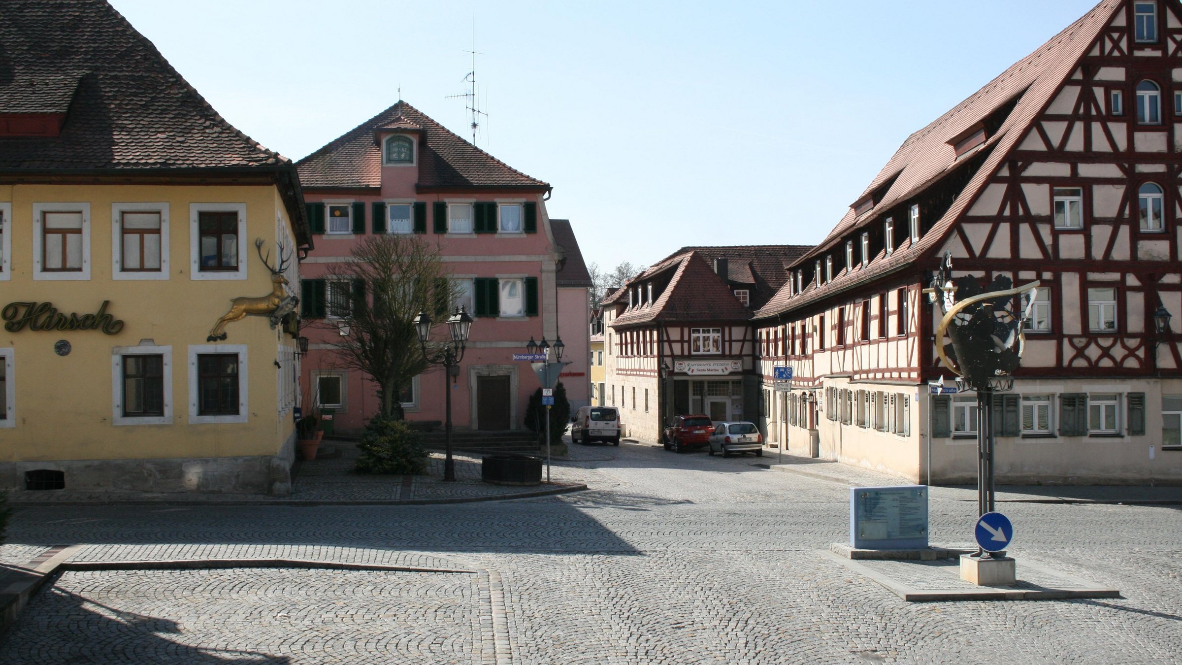 Bildbeschreibung im Sinne der Barrierefreiheit: Blick auf den Marktplatz mit historischen Gebäuden und Winddreher.