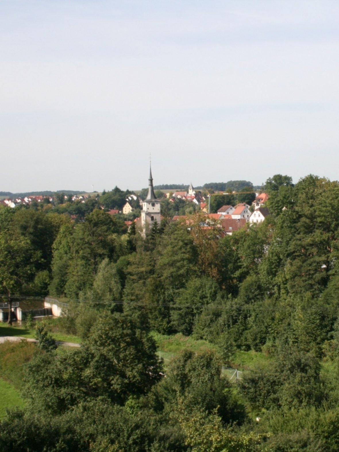Bildbeschreibung im Sinne der Barrierfreiheit: Blick vom alten Bahndamm auf Emskirchen Richtung Westen mit den Kirchen St. Kilian und Maria Königin.